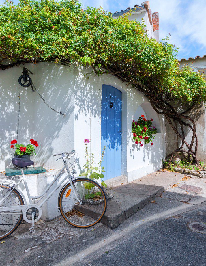 Photo intérieure d'un logement aux couleurs douces et aux arches arrondies, canapé blanc, éclairage ensoleillé